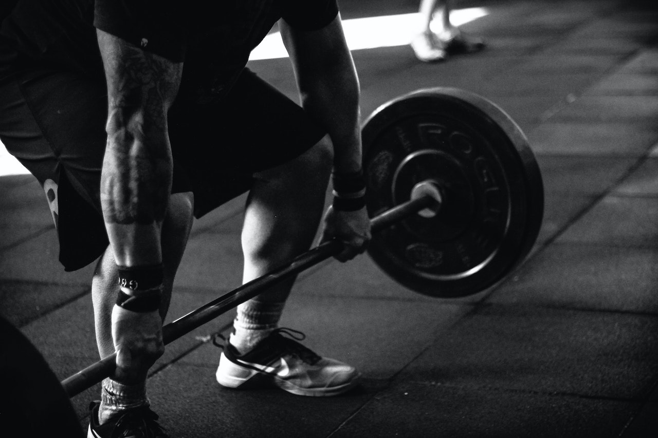 Black and white image of a man deadlifting weights.