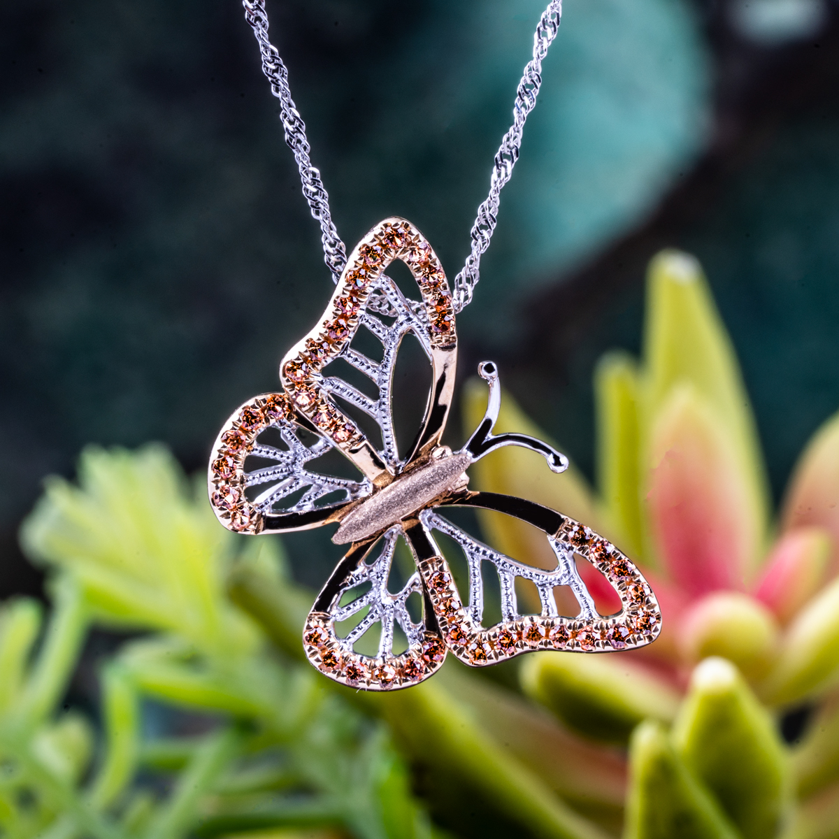 Rose and white gold diamond butterfly pendant on a twist cable chain.