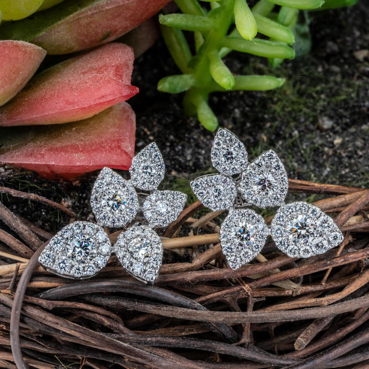 White gold leaf stud earrings set round diamonds and pear-shaped diamond haloes.