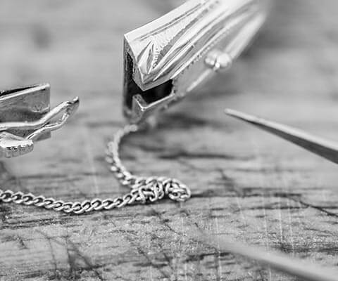 Several pieces of broken jewelry on a wooden table.