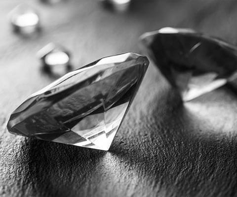 Several loose round cut diamonds on a wooden table.