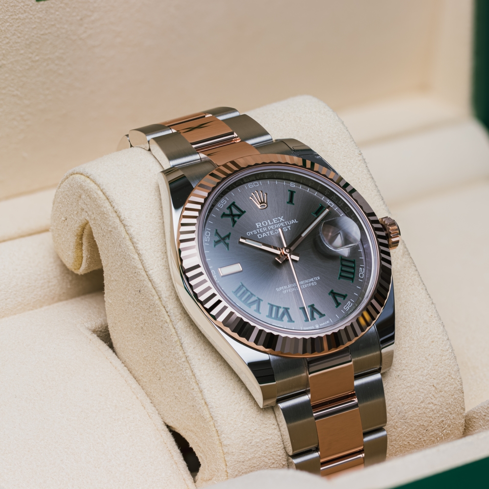 Rolex Datejust in stainless steel with a gray Roman numeral dial and green markers.