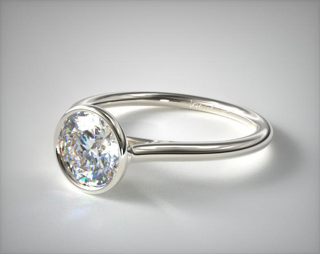 White gold ring centered with a bezel set round diamond.