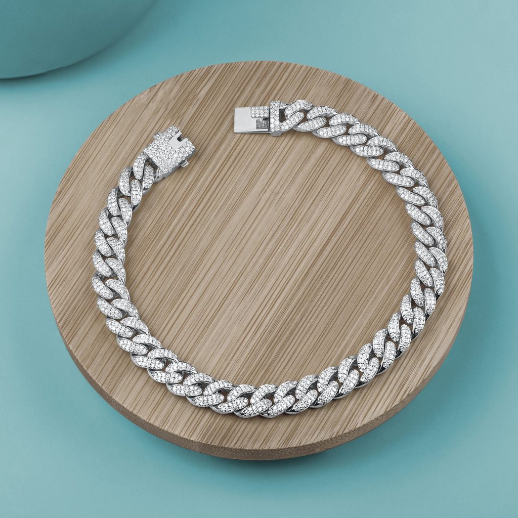 White gold lab-grown diamond link bracelet on a wooden tray.