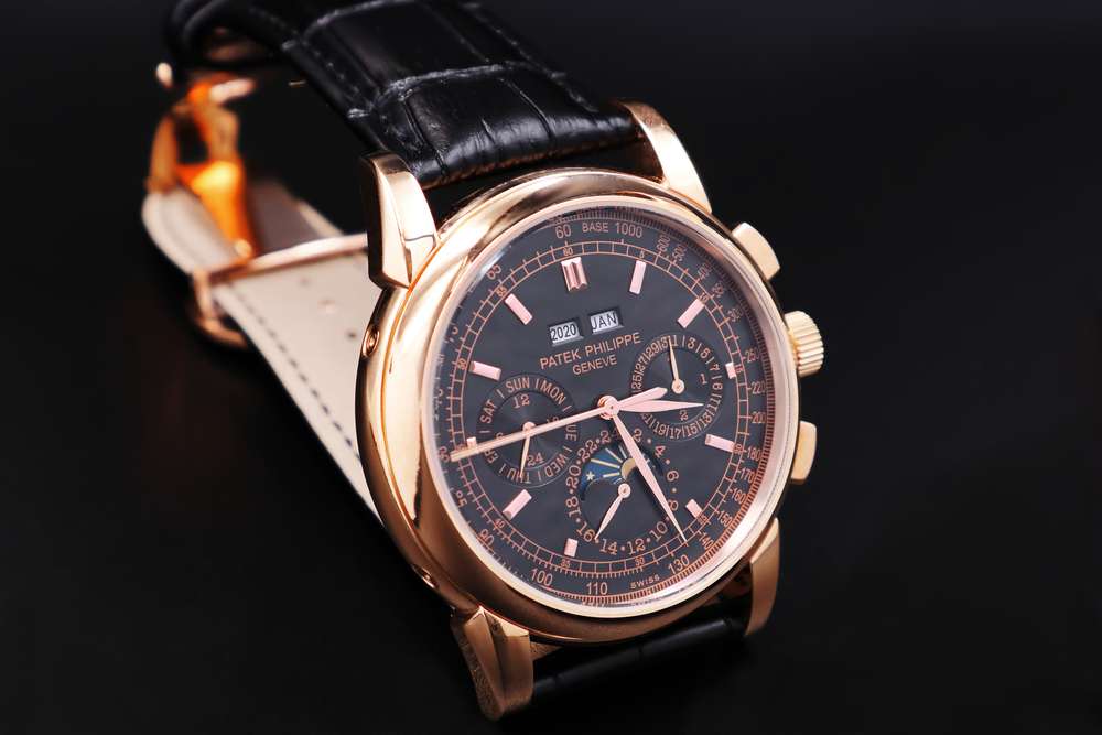 Rose gold Patek Philippe with black dial and black leather strap.