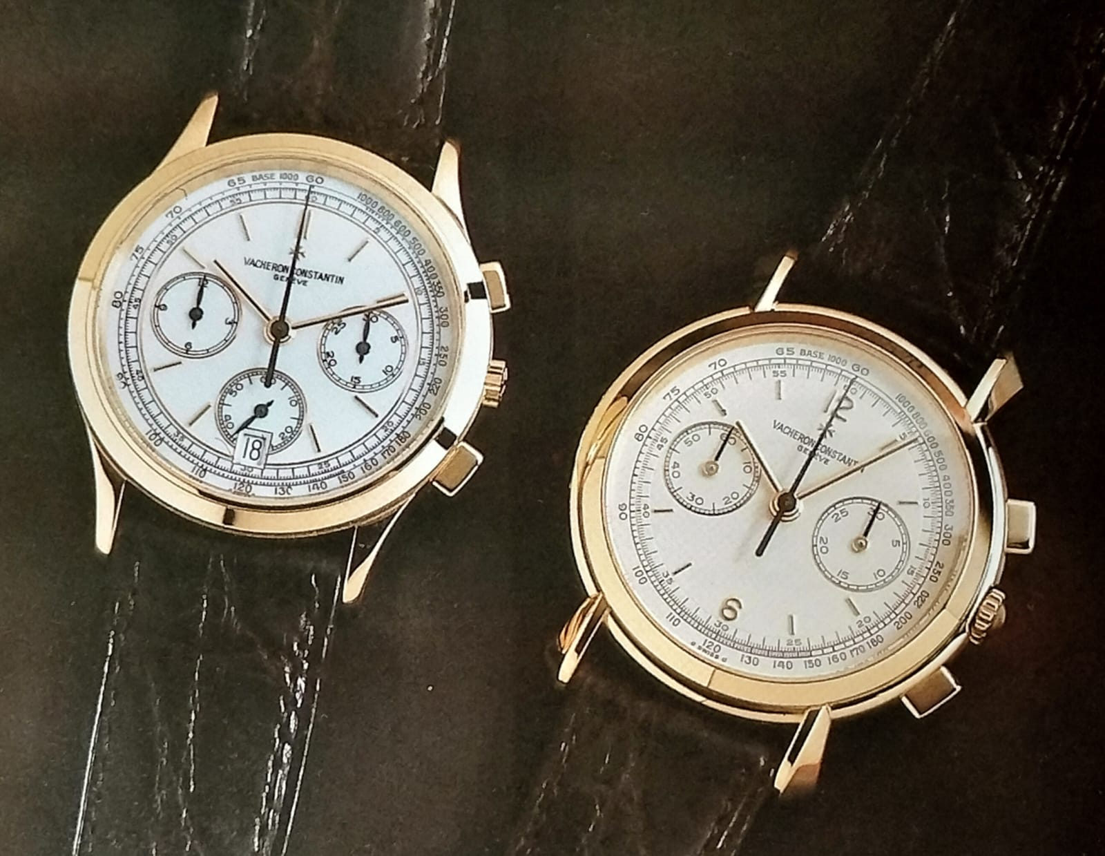 Two yellow gold Vacheron Constantin watches with white dials and leather straps laying flat on a table.