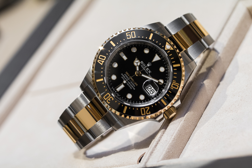 Men's Rolex Submariner in stainless steel and yellow gold with a black dial, white markers, and black ceramic bezel.