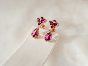 Yellow gold floral dangle earrings set with rubies.