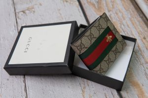 Vintage Gucci men's wallet with red and green stripes & "GG" monogram print.