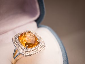 Cushion cut citrine ring surrounded by a double diamond halo.