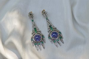 Vintage art deco earrings set with diamonds and purple and green gemstones.