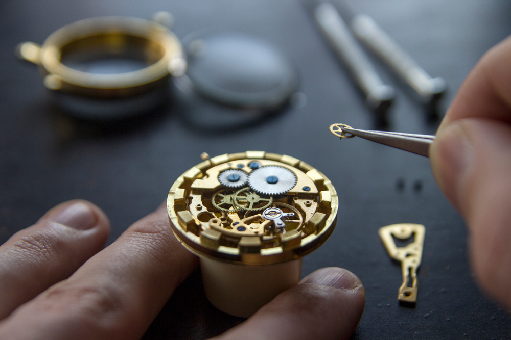Watchmaker working on inner gears and jewels of a fine watch.