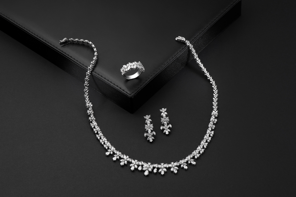 Platinum tennis necklace, earrings, and ring set with diamonds.