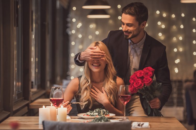 Man surprising woman with romantic Valentine's dinner.