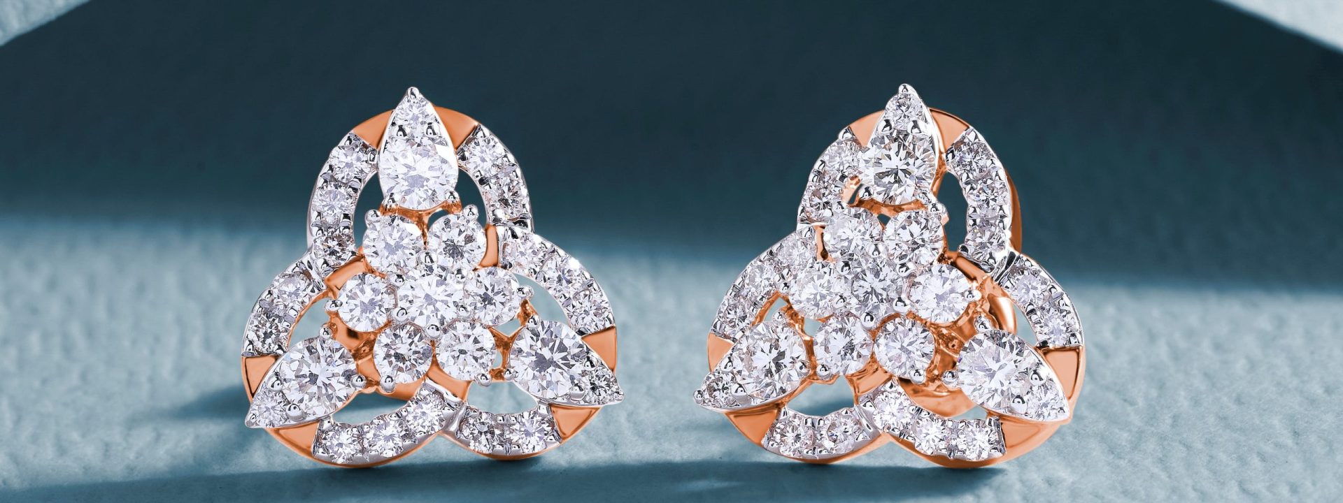 Rose gold three-leaf clover twist stud earrings set with lab-grown diamonds.