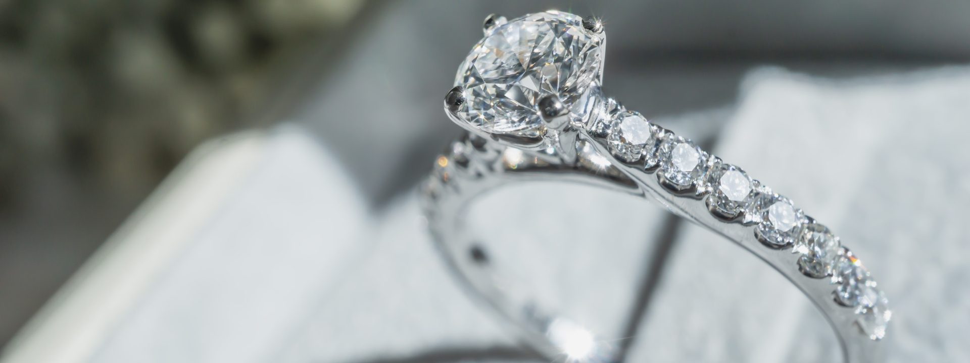 JSSD BannerIn-Text (1) White gold cathedral diamond engagement ring with diamonds in the band.