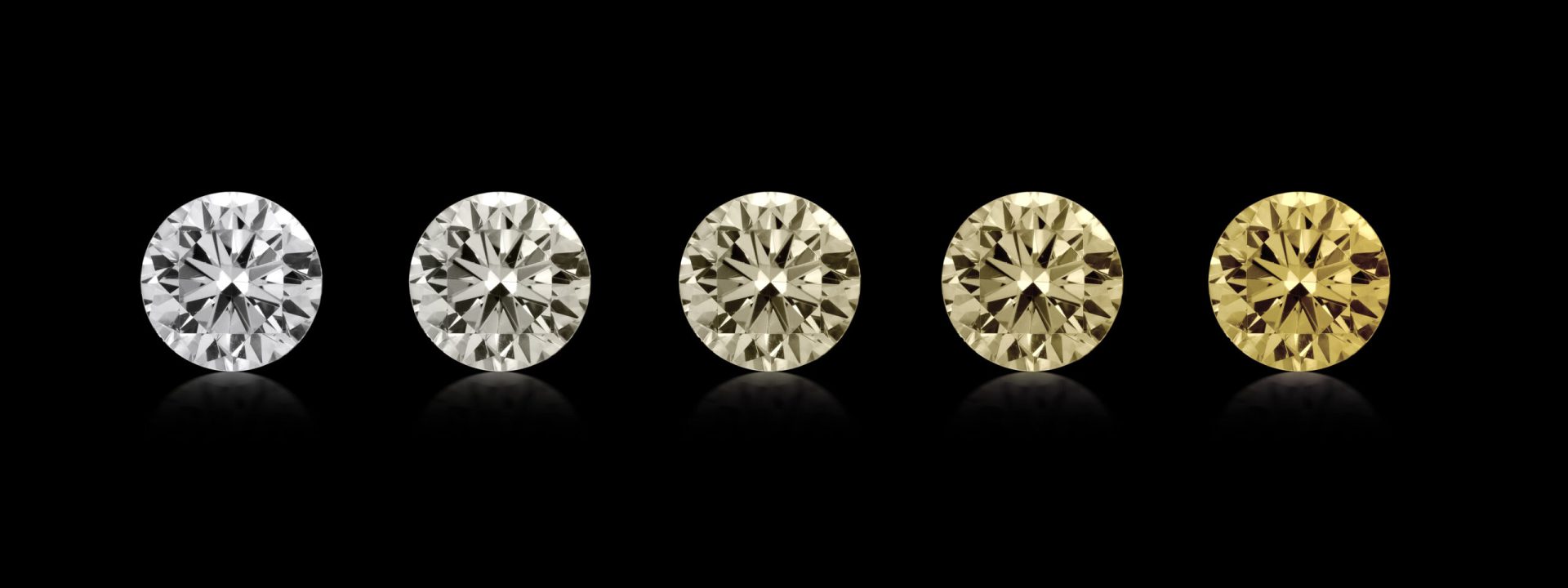 Five round cut loose diamonds showing the range of yellow diamonds.