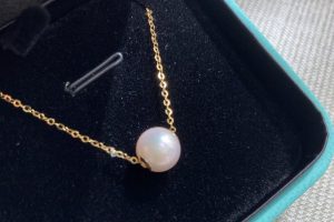 Yellow gold Tiffany & Co. station pendant set with a white pearl.